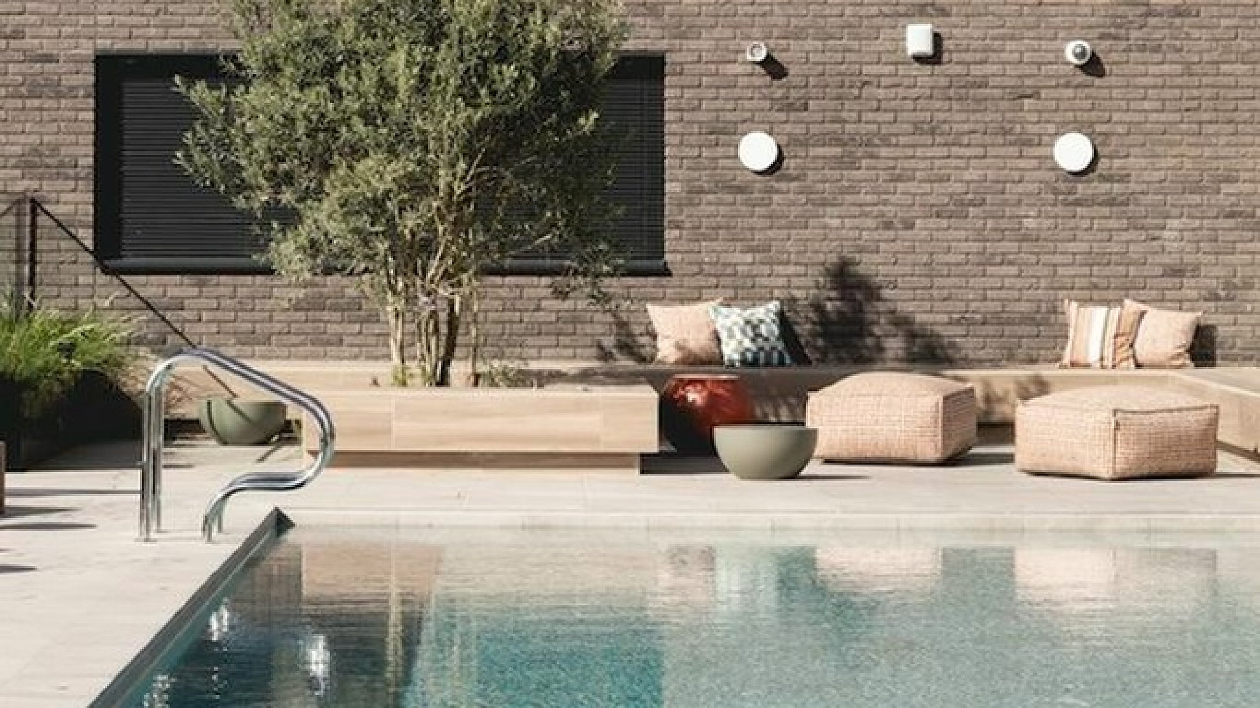 Chic outdoor pool area with elegant lounge chairs and stylish wicker seating, perfect for relaxation and leisure.