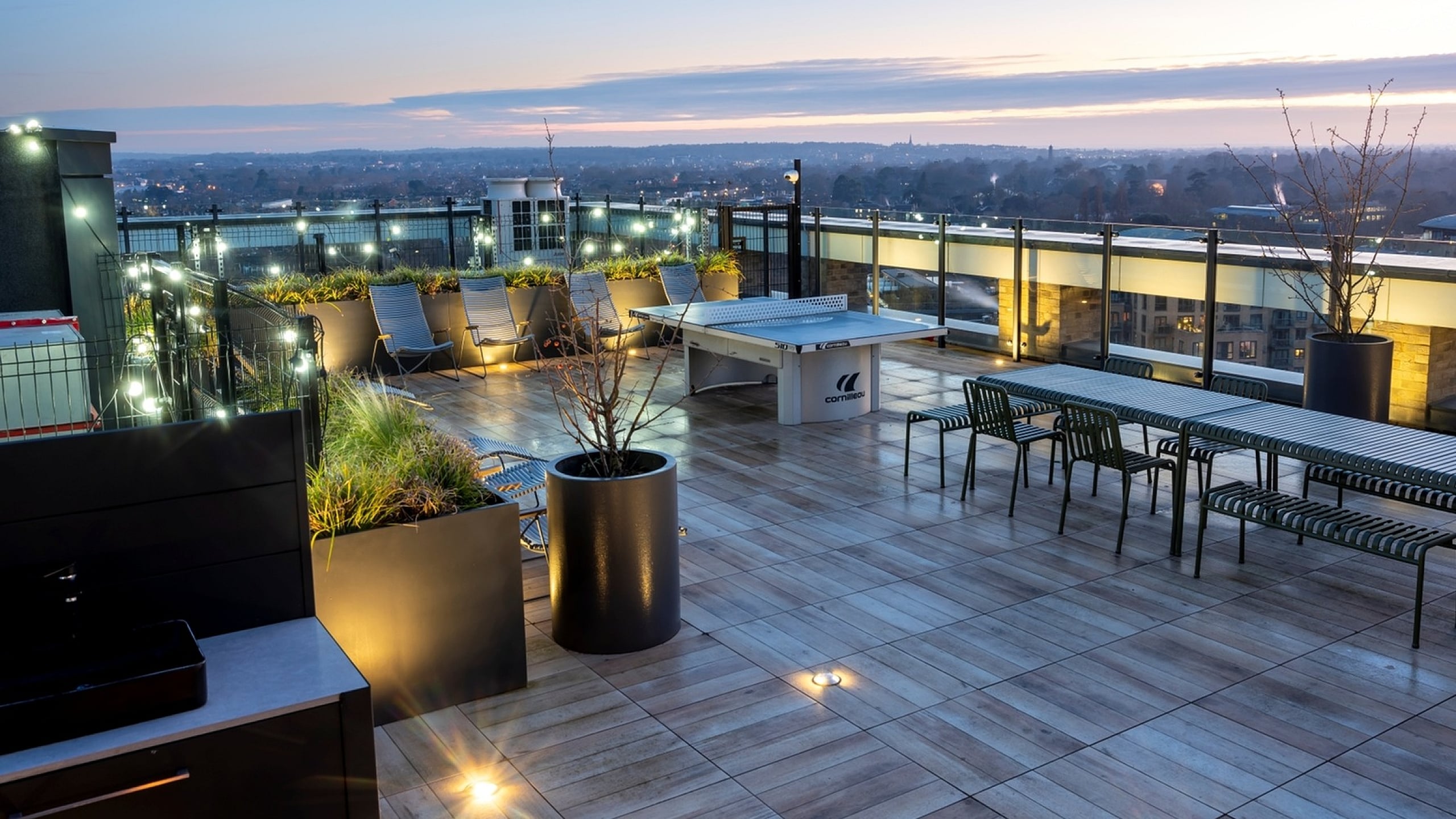 Breathtaking rooftop terrace at sunset with stylish seating, ambient lighting, and panoramic city views.