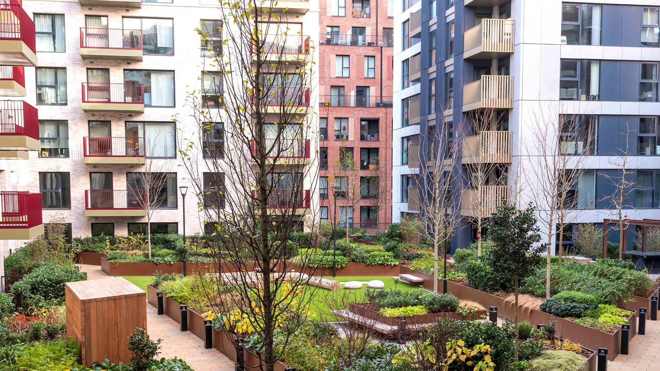 Modern apartment complex with lush, landscaped courtyard gardens and stylish architecture.