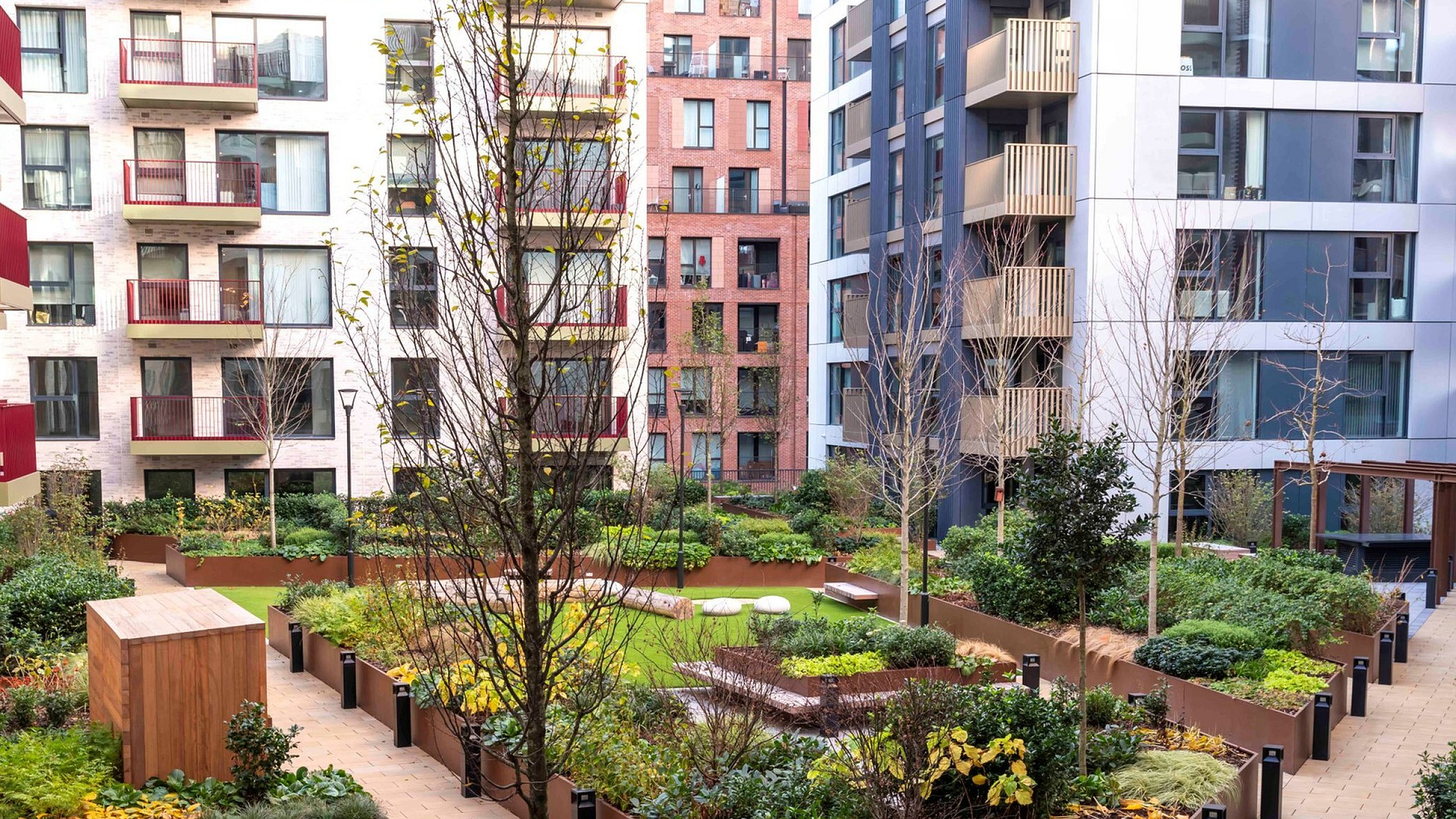 Charming apartment complex courtyard featuring lush landscaped gardens, modern architecture, and inviting walkways.