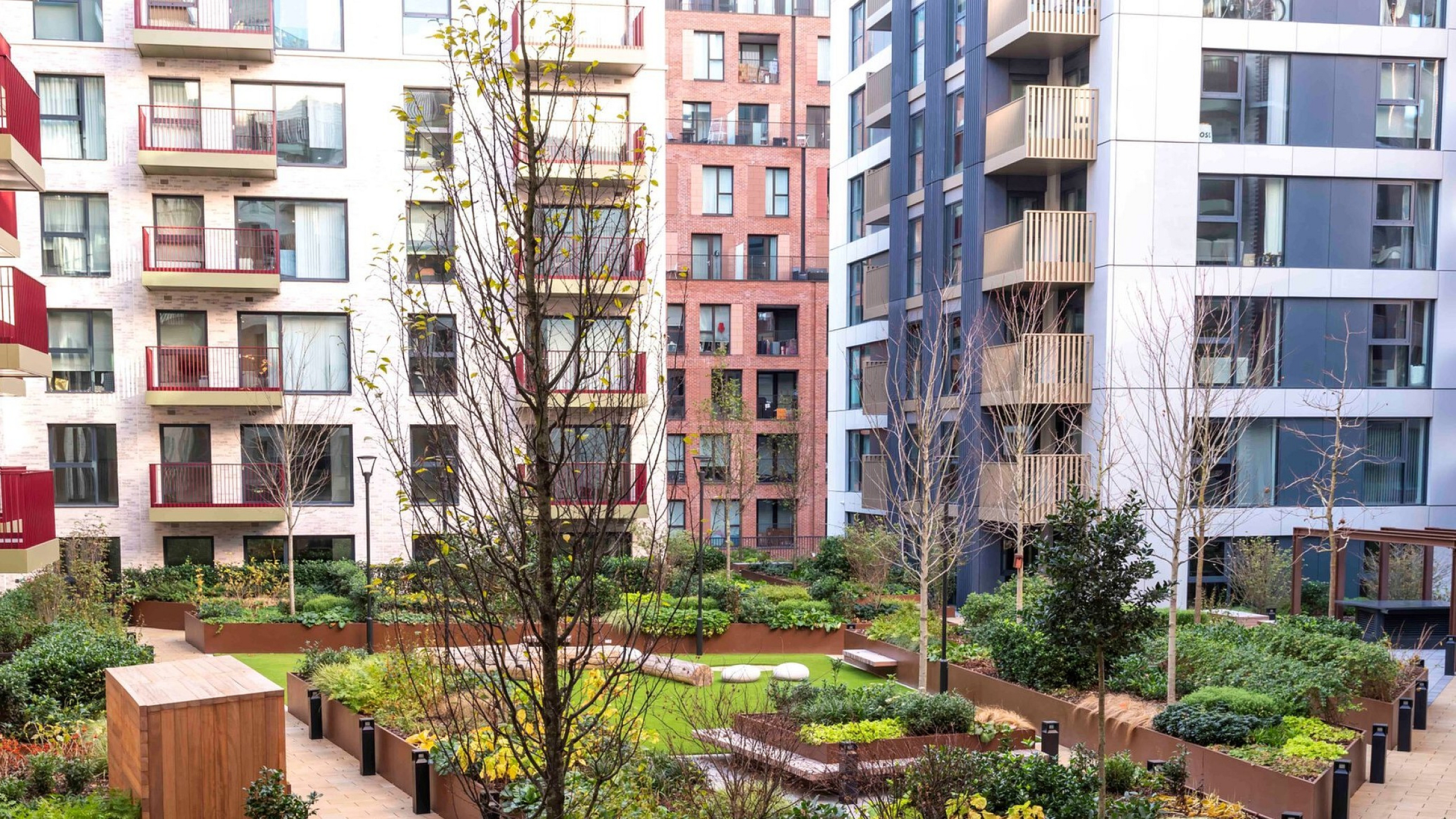 Vibrant courtyard garden with lush greenery and modern apartment balconies, offering a serene urban oasis.