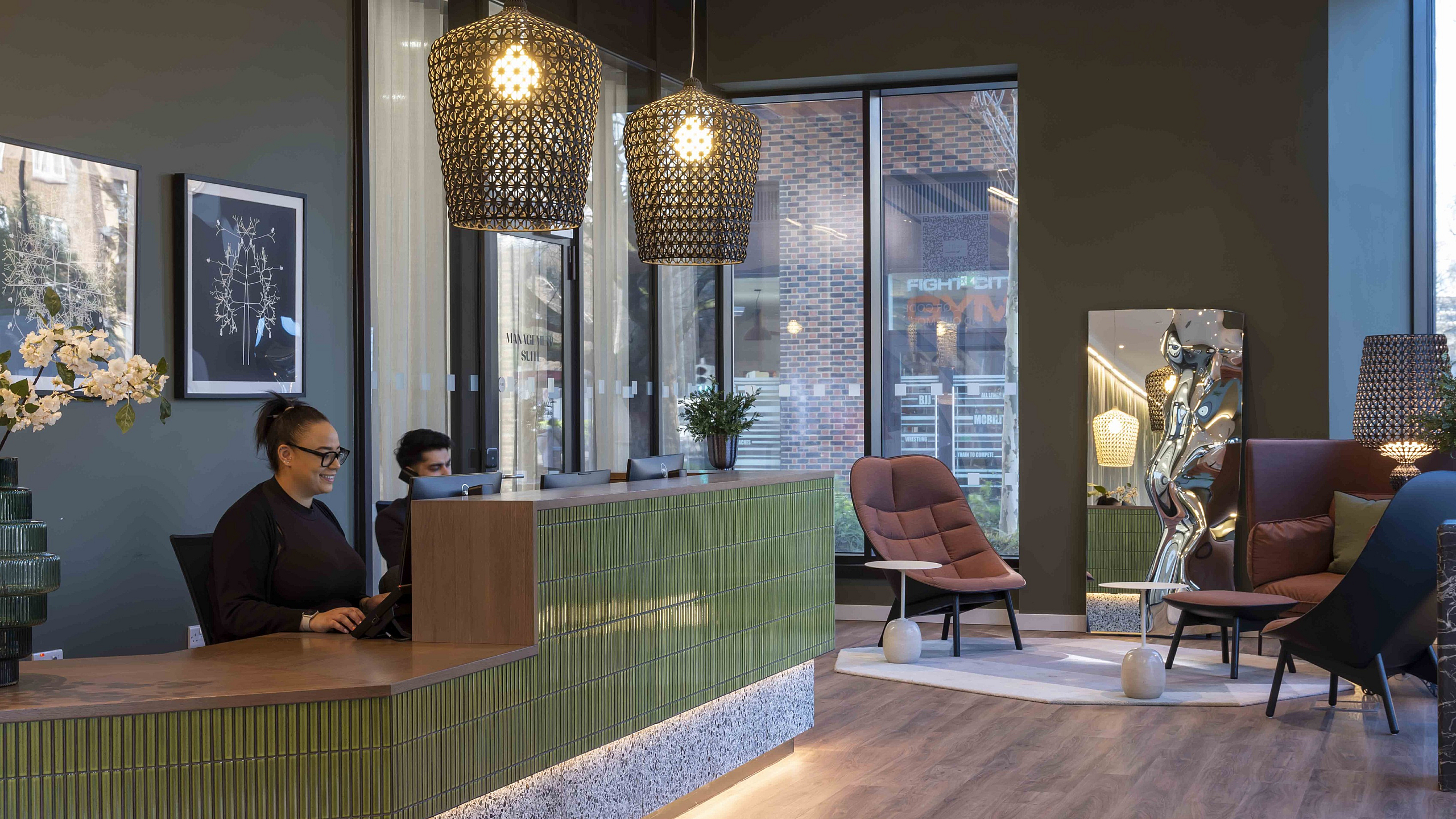 Chic apartment reception area with modern decor, stylish green accents, and elegant seating for a welcoming ambiance.