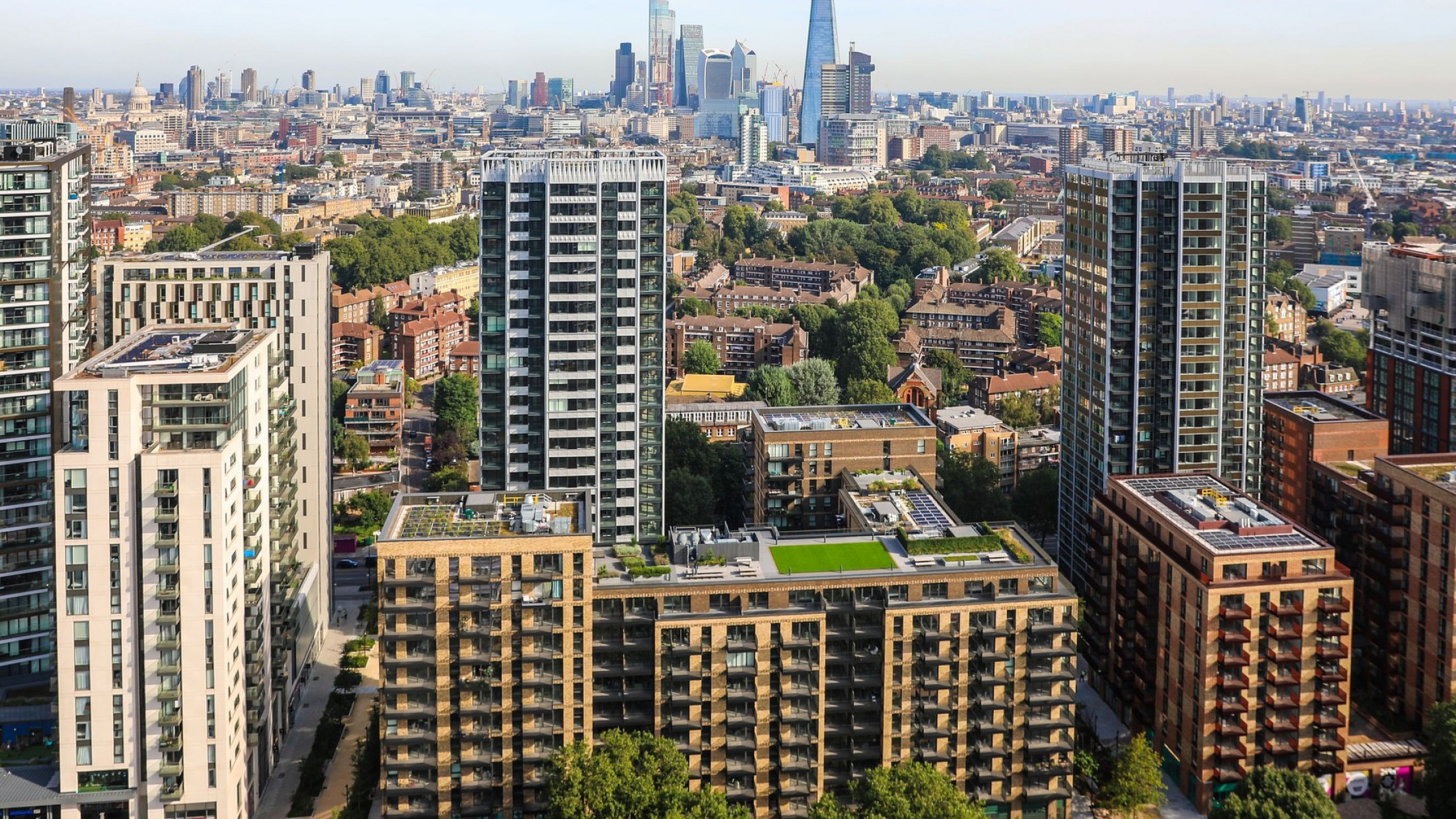 Breathtaking cityscape featuring modern high-rise apartments with panoramic views of the skyline and lush greenery below.