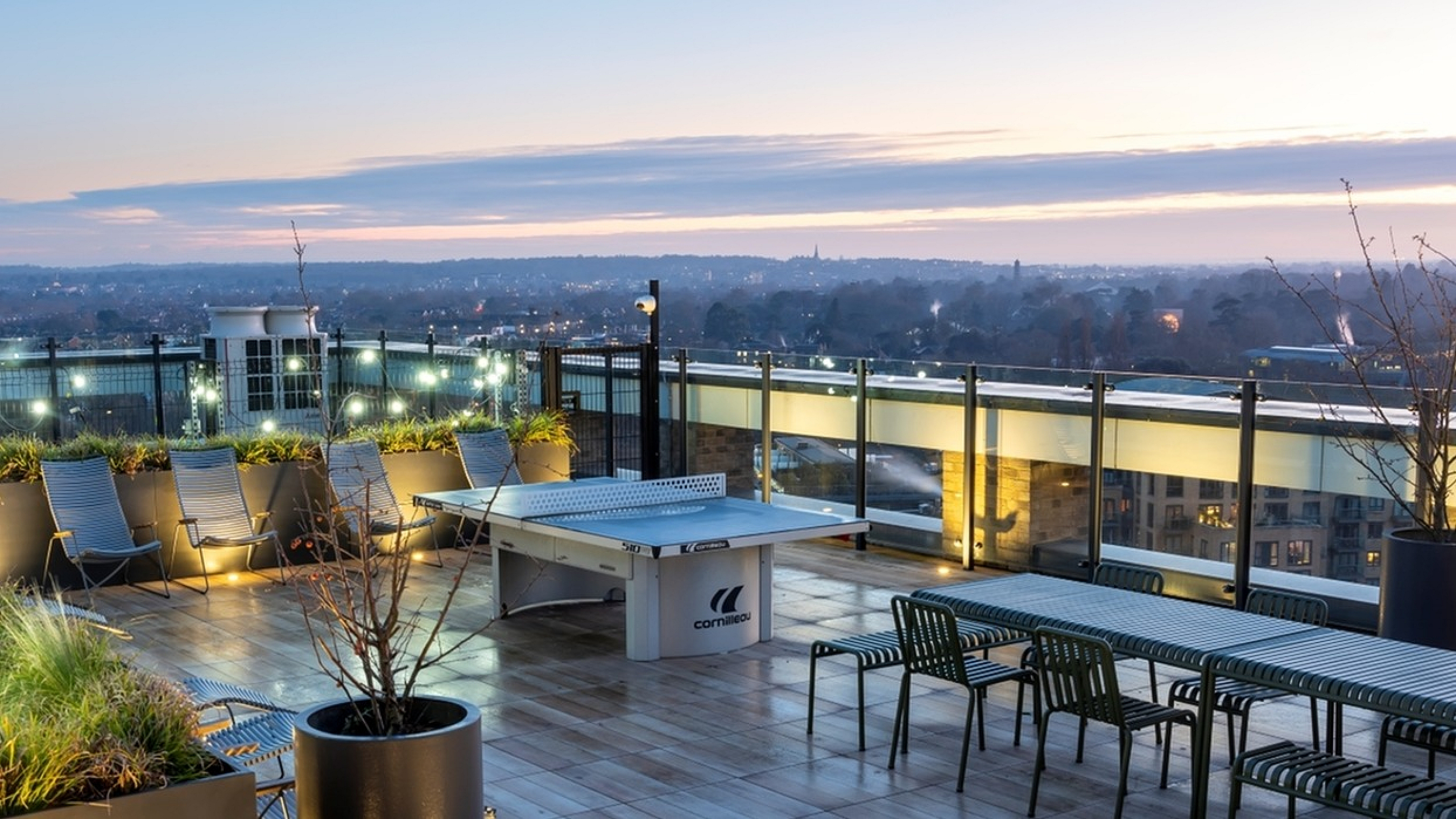 Stunning rooftop terrace with panoramic views, stylish seating, and ambient lighting at sunset.