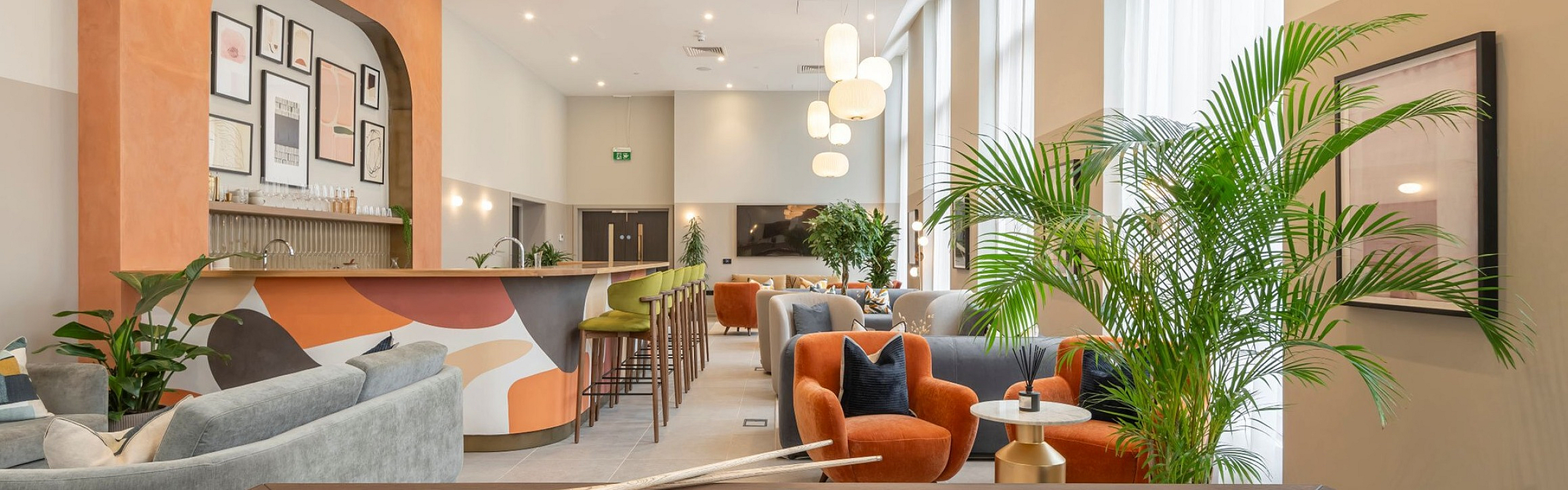 Chic lounge with modern decor featuring a vibrant bar, plush seating, and a stylish pool table for a luxurious entertainment experience.