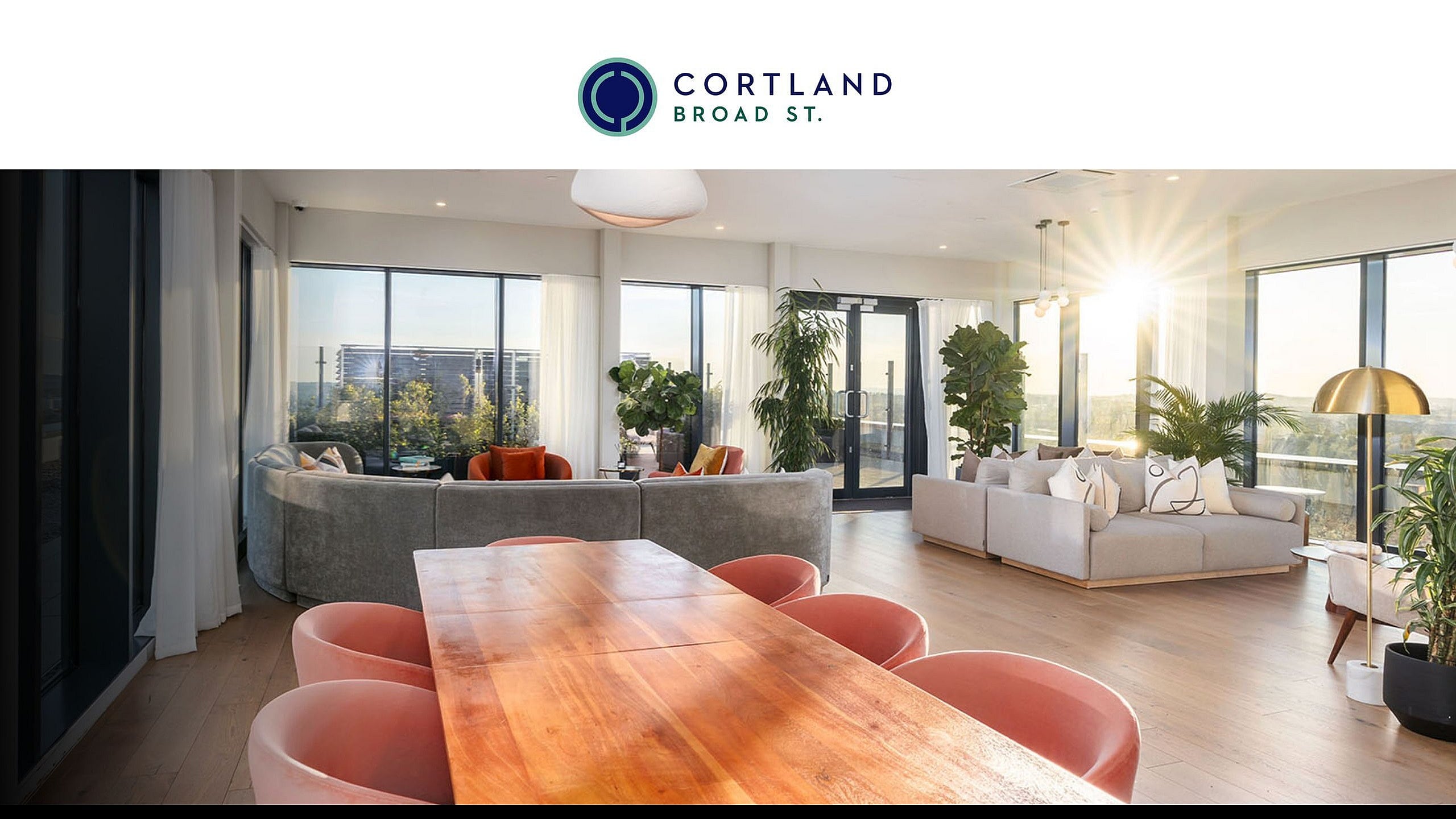 Stunning contemporary living room with floor-to-ceiling windows, lush greenery, and elegant seating, bathed in natural light.